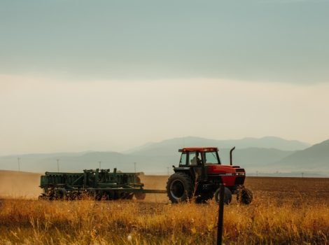 red and black tractor on brown grass field during daytime