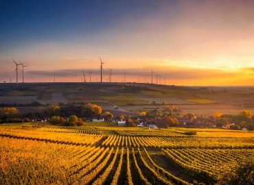Breathtaking view of a countryside landscape with wind turbines and vivid sunset.